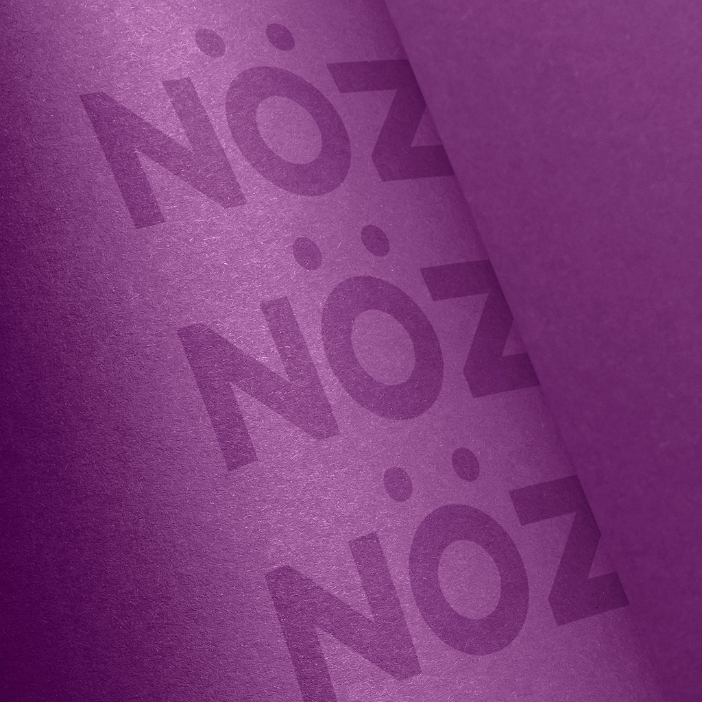 Zoomed in view of Nöz brand name on purple sunscreen bottle 